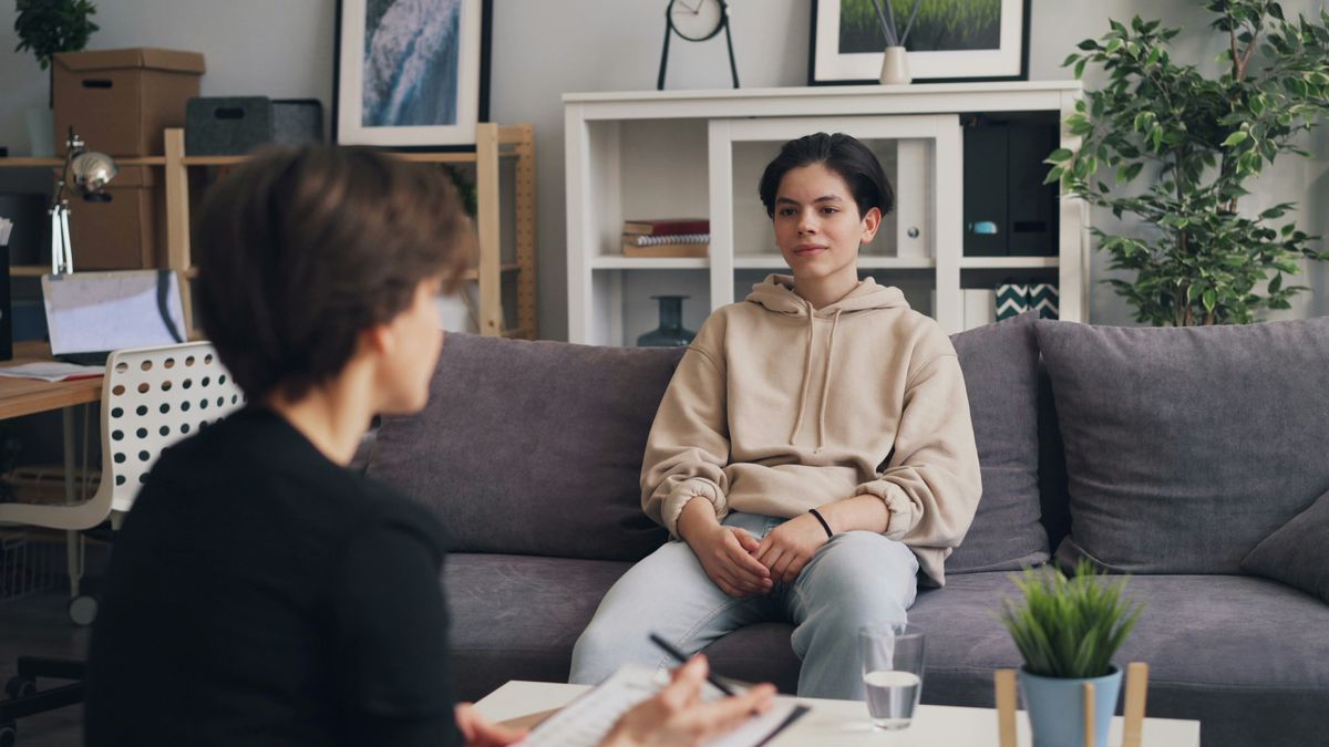 A parent facilitator meets with a teen in a calm office setting.
